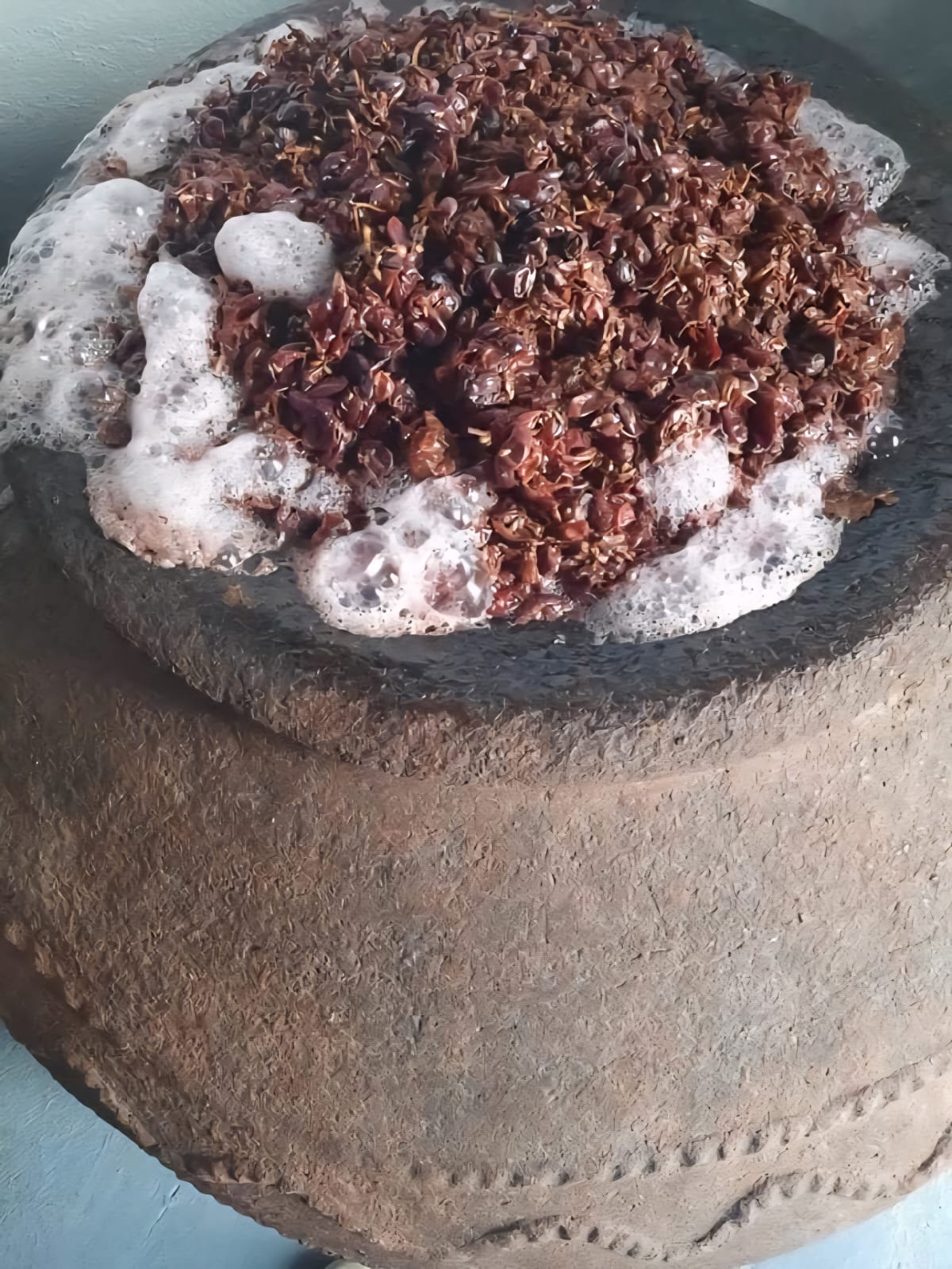 Mavro grape must fermenting naturally inside a century-old terracotta pithari